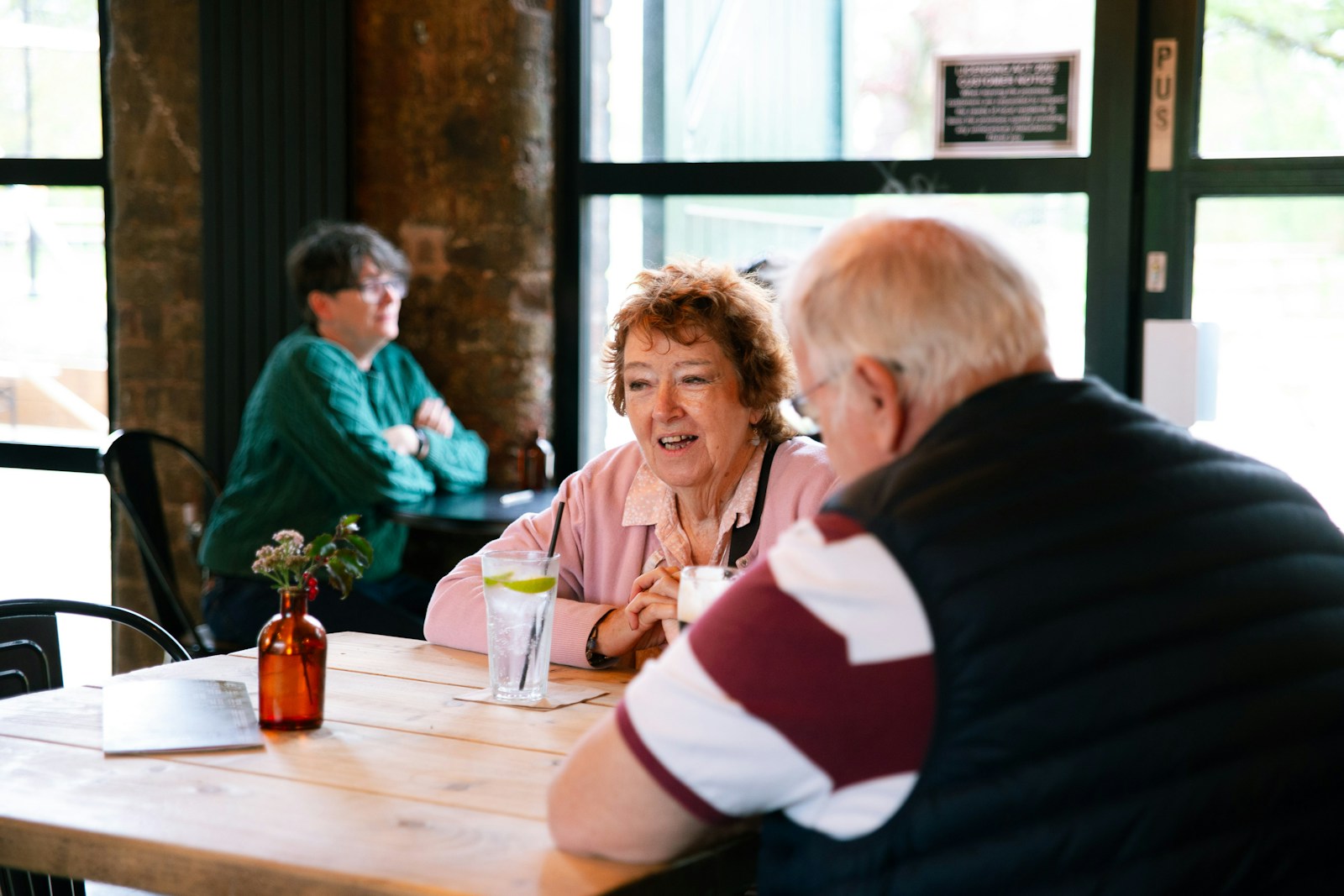 People sharing a conversation around a cafe table